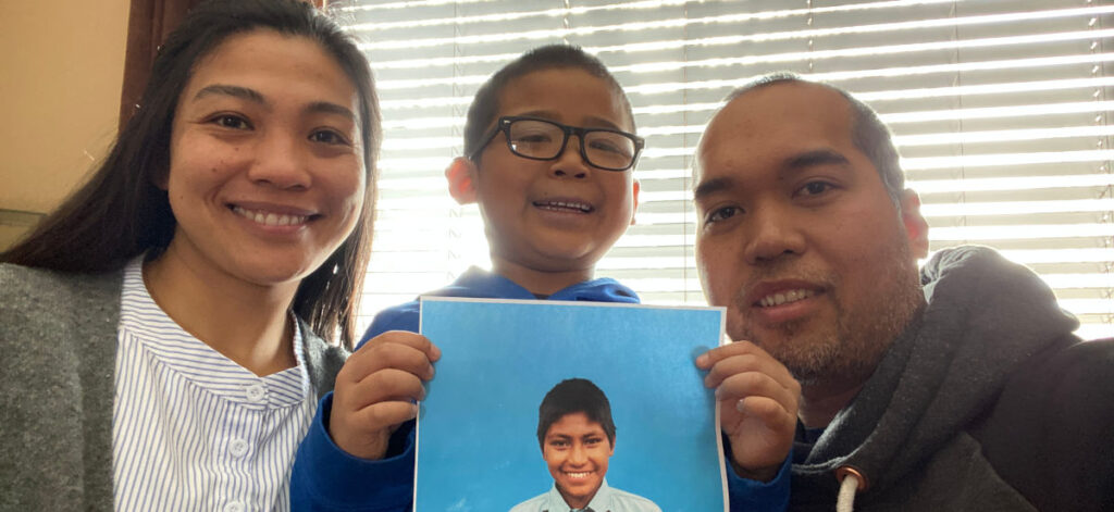 Rowena and her family holding a photo of their sponsor child