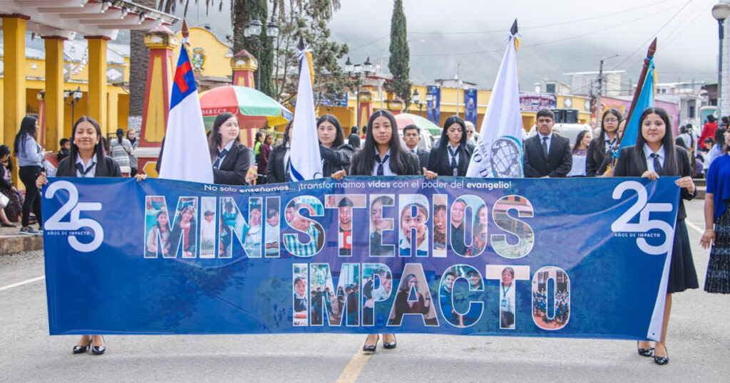 Vida Junior High Students in School Uniform parading with "25 Ministerios Impacto" banner